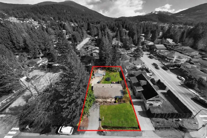 Expansive lot featuring a primary residence, detached garage, and a lush green lawn