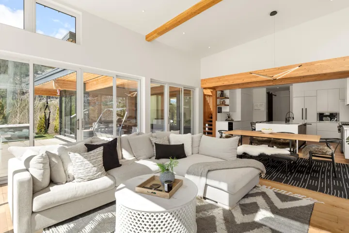 Contemporary living area with high ceilings and exposed wood beams