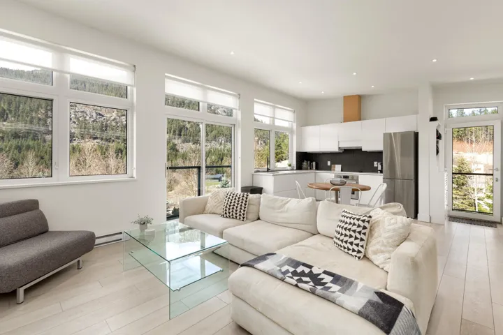 Open-concept living space featuring light wood-finish flooring, recessed lighting, and expansive windows