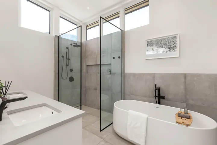 Bathroom featuring a freestanding oval tub and dual walk-in showers with glass partitions