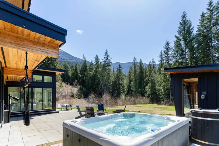 Outdoor hot tub and wooden soaking tub on a stone patio