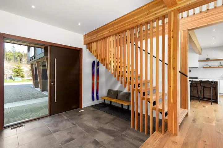 Contemporary wooden staircase with slatted railing and dark balusters