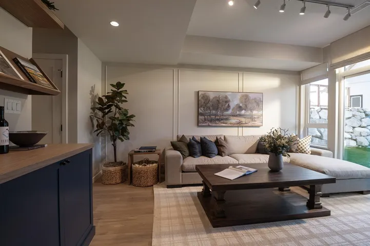 Living area featuring wood-finish flooring and a built-in dark blue cabinet with a wood countertop