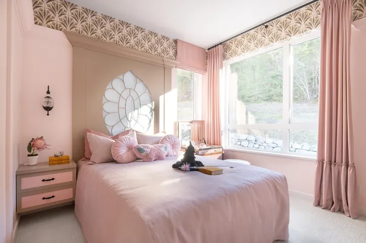 Bedroom featuring a built-in headboard with an integrated decorative panel, extensive window glazing, and a wall-mounted sconce