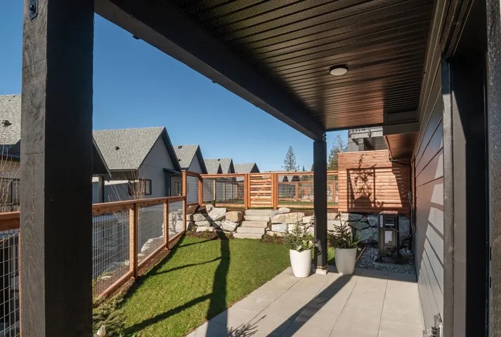 Covered outdoor patio with a concrete walkway and dark wood ceiling