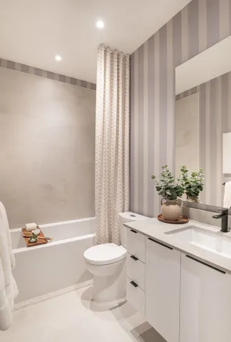 Contemporary bathroom featuring a modern vanity with integrated sink, matte black faucet, and stone-finish countertop