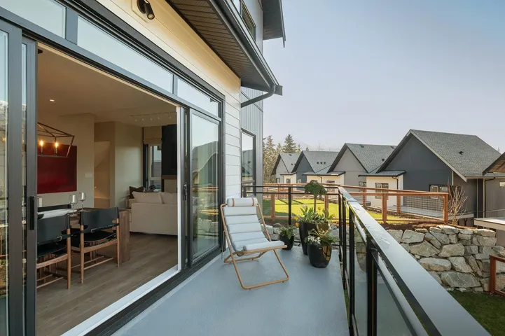 Outdoor balcony featuring a glass railing system and a light gray finished floor