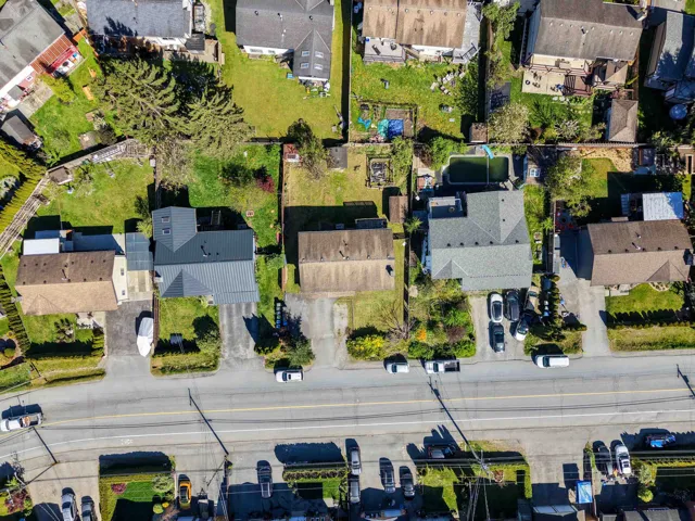 Aerial view showcasing multiple residential properties, each featuring individual driveways and private green spaces