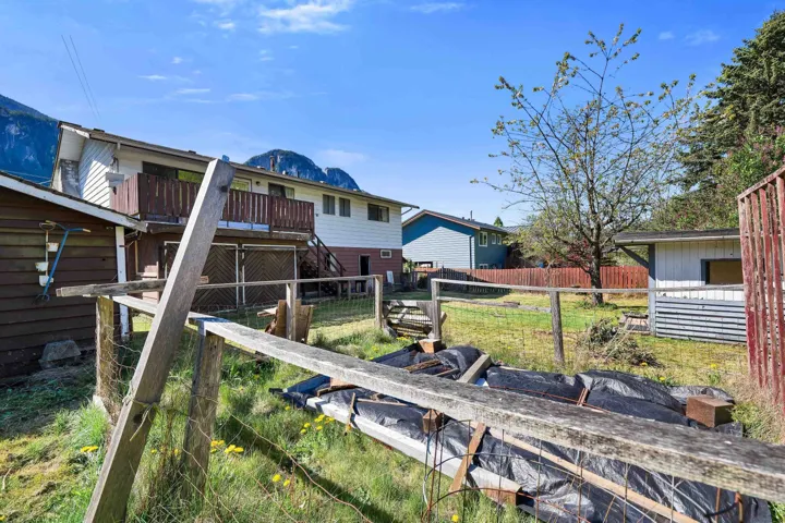 Two-story residence with a wood-railed balcony and ground-level patio space