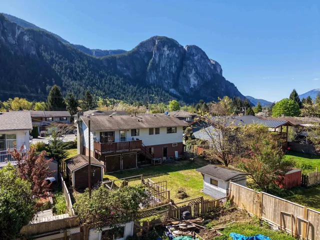 Expansive backyard featuring a multi-level deck, two storage sheds, and a wood privacy fence