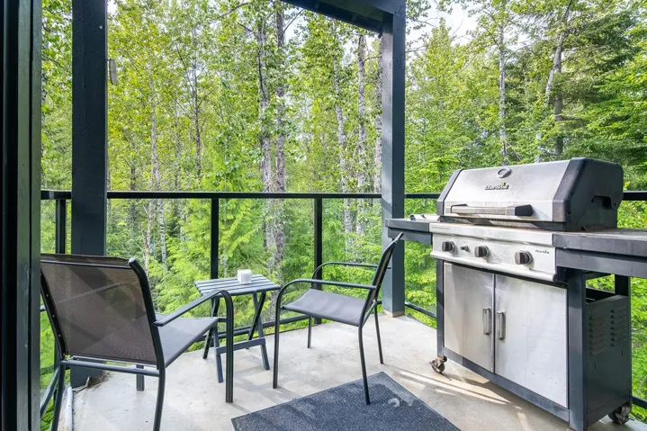 View of patio with a grill and a wooded view