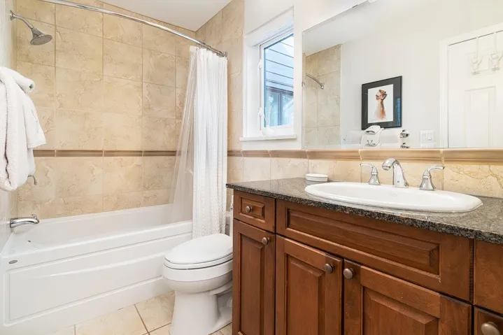 Full bath with vanity, shower / bathtub combination with curtain, and tile patterned flooring