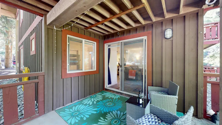 Property entrance with board and batten siding and a wooden deck