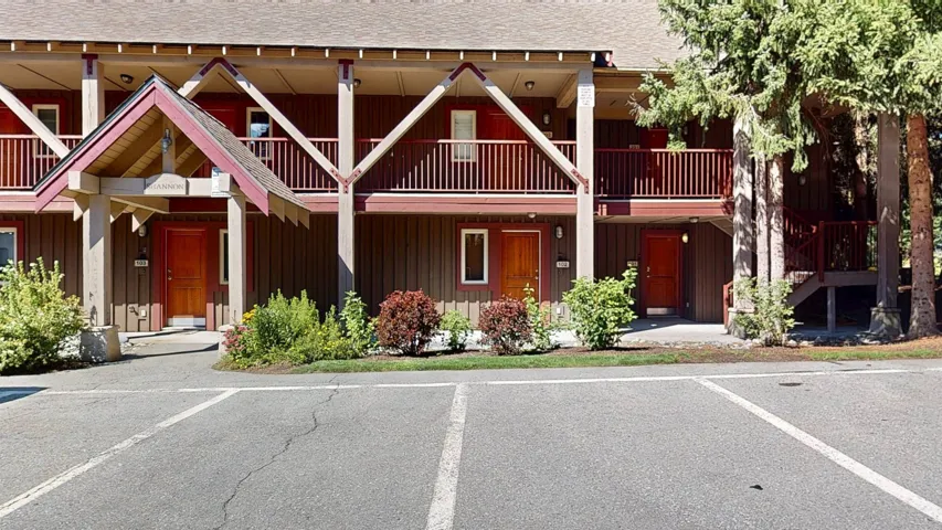 View of front of property with board and batten siding, a shingled roof, and uncovered parking