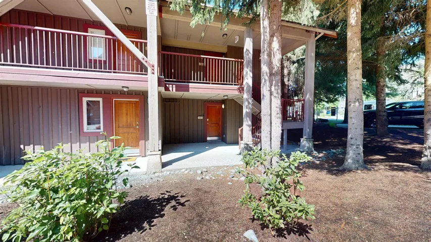 View of exterior entry featuring board and batten siding and a patio area