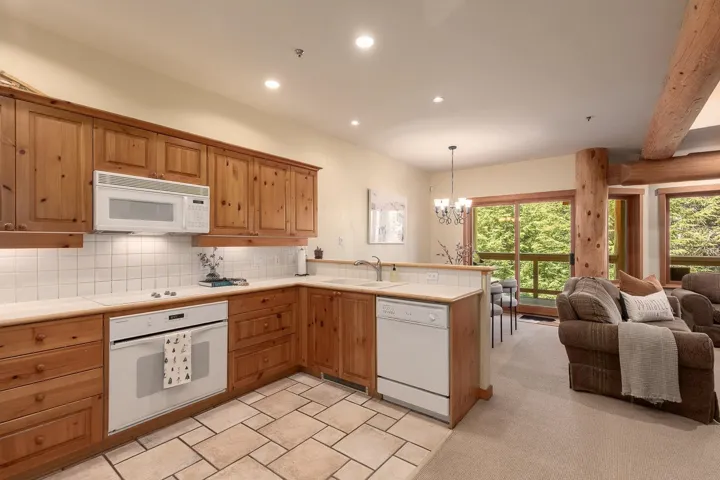 Spacious kitchen featuring pine wood cabinetry, light-toned countertops, and a white tile backsplash
