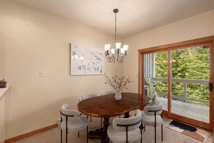 Dining area with a multi-light chandelier and wood trim accents