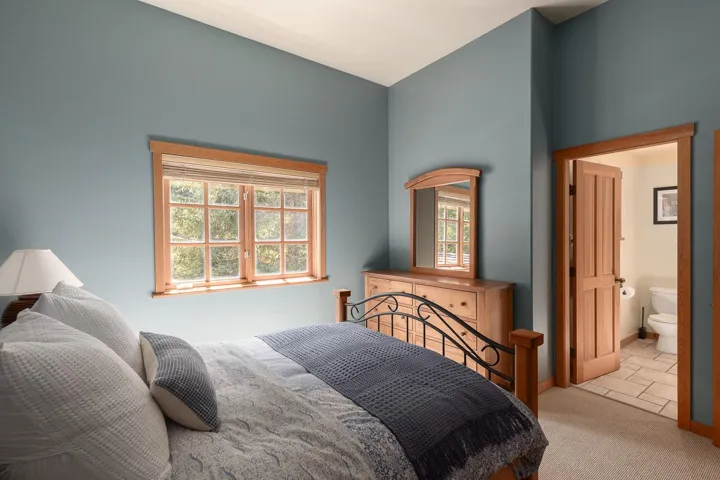 Room with blue walls, wood-trimmed window, and wood door frame