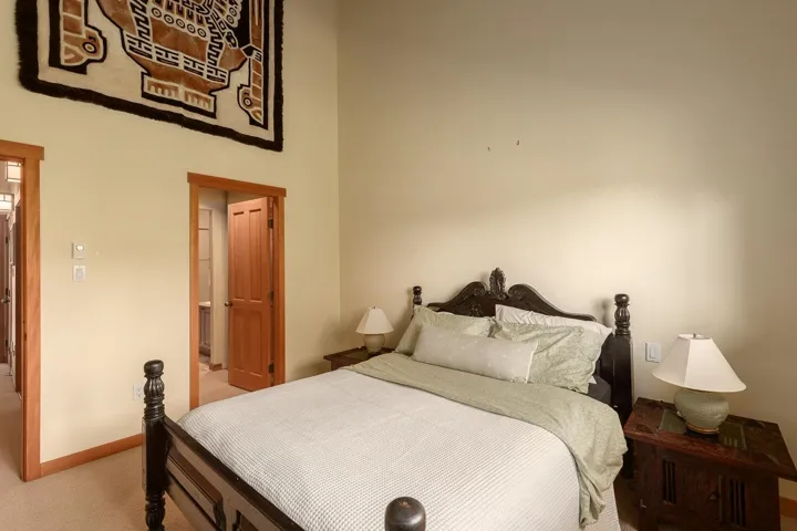 Carpeted room featuring light-colored walls and natural wood trim around doorways