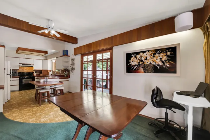 Office area with a ceiling fan, french doors, and light floors