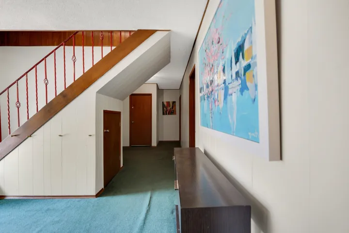 Hallway featuring dark carpet