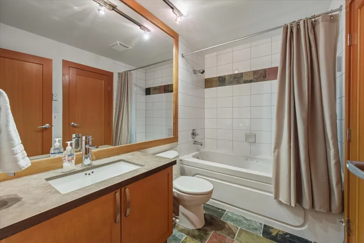 Bathroom featuring shower / bath combination with curtain and vanity