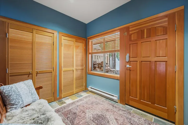 Entrance foyer with baseboard heating and stone tile flooring