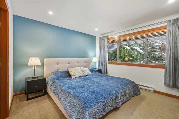 Bedroom with carpet flooring, baseboard heating, and recessed lighting