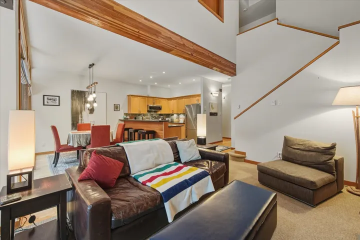 Living area with a towering ceiling, light colored carpet, and recessed lighting