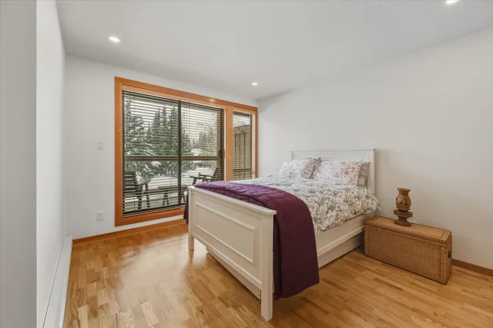 Bedroom with light wood finished floors, baseboard heating, and recessed lighting