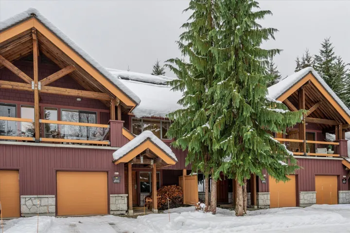 Snow covered property with an attached garage