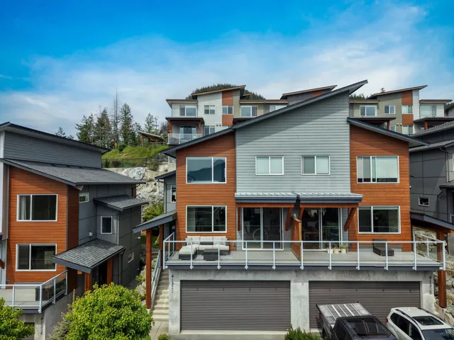 Contemporary multi-level residence featuring a multi-pitched roofline and a combination of horizontal siding and wood-finish paneling