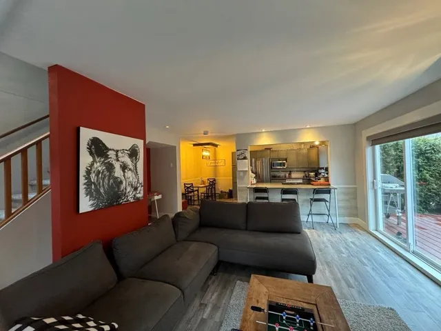 Living room with stairs, light wood-type flooring, and baseboards