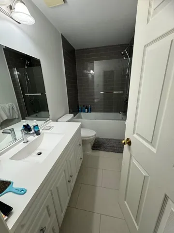 Full bath featuring tile patterned flooring, vanity, shower / bathing tub combination, and toilet