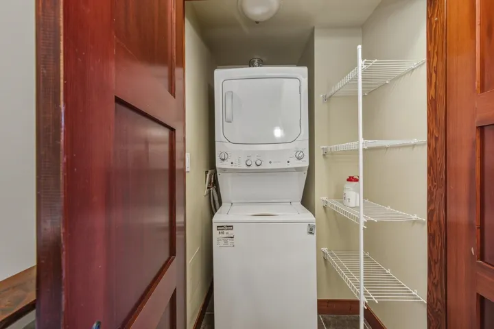 Washroom featuring stacked washer / drying machine