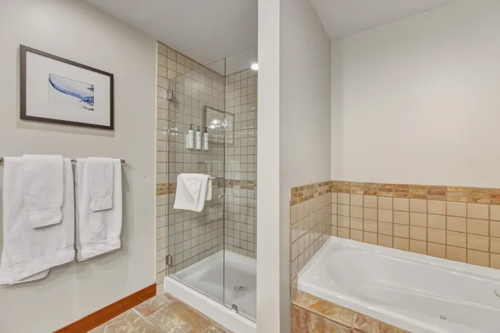 Full bath with a tub with jets and a stall shower