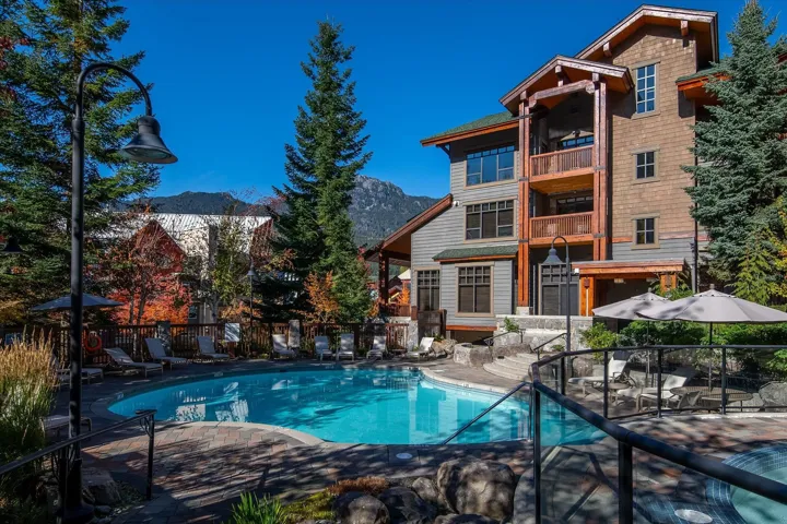 Back of house featuring a patio, a mountain view, a community pool, and a balcony