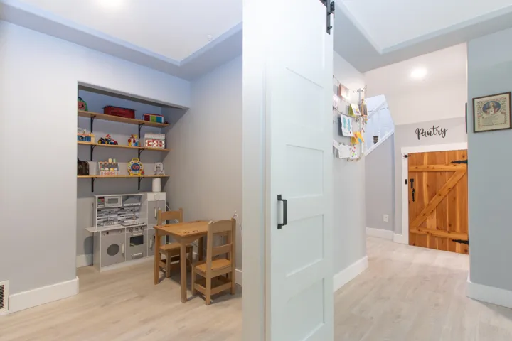 Entryway featuring wood finished floors, a barn door, and stairs