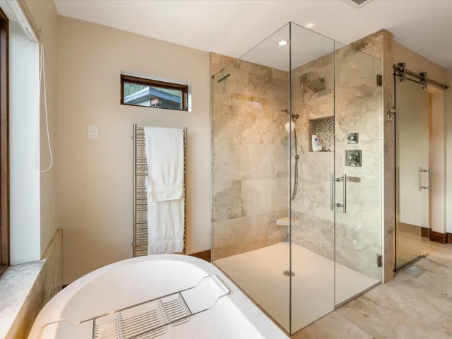 Full bathroom featuring a towel warmer, a stall shower, a bathtub, and recessed lighting