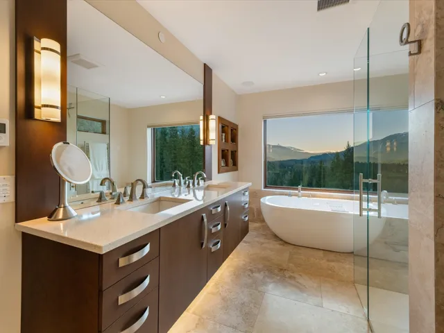 Bathroom with double vanity, a freestanding bath, and a mountain view