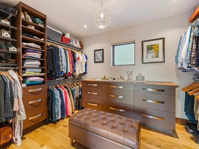 Walk in closet with light wood-style flooring