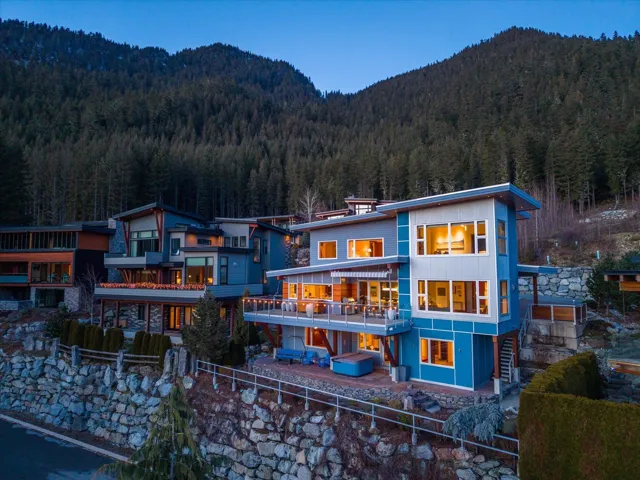 Back of house featuring a mountain view, stairs, and a view of trees