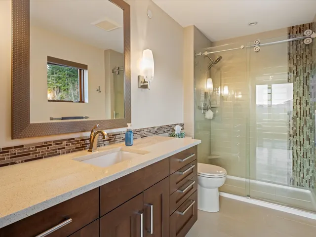 Bathroom with vanity, a shower stall, tasteful backsplash, and light tile patterned floors