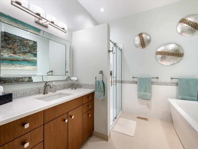 Bathroom featuring a bath, vanity, a stall shower, and decorative backsplash