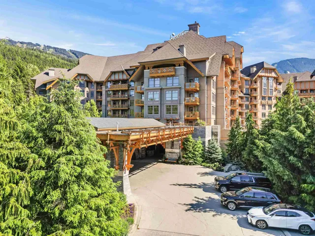 View of building exterior with driveway, a carport, and a mountain view