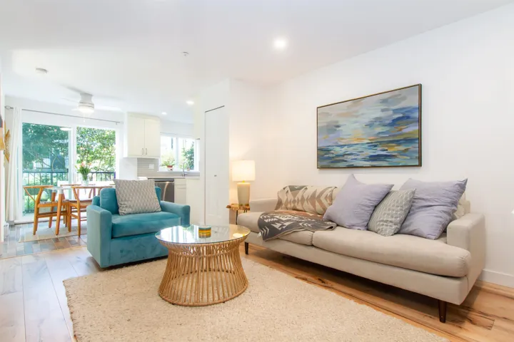 Bright, open-concept living area featuring hardwood flooring throughout, recessed ceiling lighting, and large windows with natural light