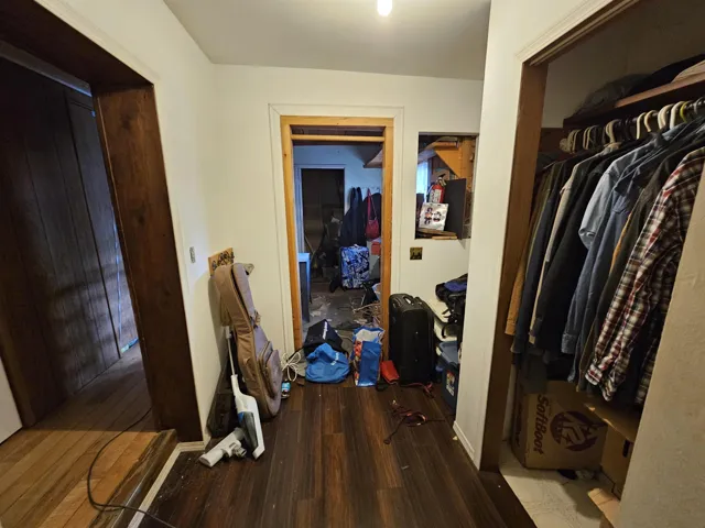 Corridor featuring dark wood-style floors and baseboards