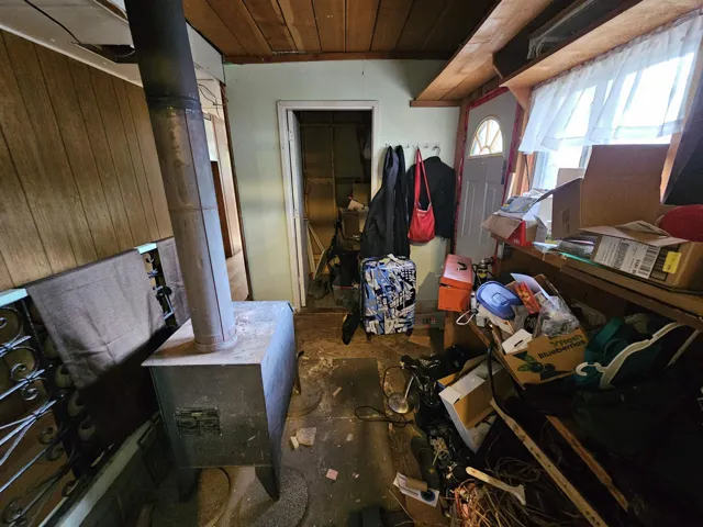 Misc room featuring wooden walls, a wood stove, and wooden ceiling