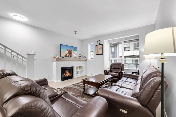 Living room featuring a glass covered fireplace and wood finished floors