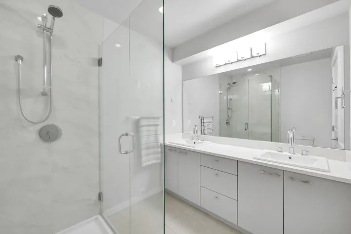 Full bathroom with double vanity, a stall shower, and light tile patterned floors